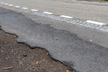 Defekte Asphalt strasse mit weisser Markierung