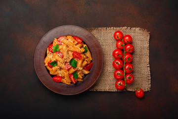 Pasta with cheese and cherry tomato on rusty background