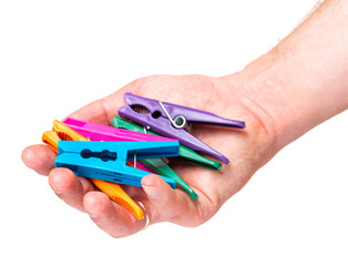 Color clothespin in male hand isolated on white background. Man hand with colourful clothes-pin - close-up.