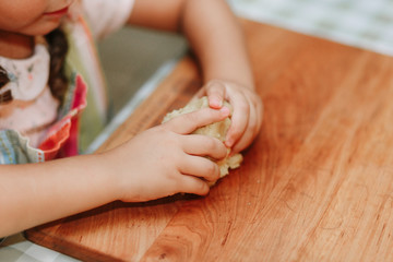 Child mixing flour in the kitchen, making dough