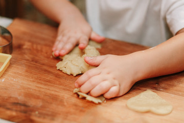 Child mixing flour in the kitchen, making dough