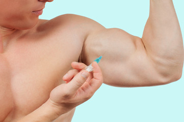Obraz na płótnie Canvas Bodybuilder taking steroids injection in arm