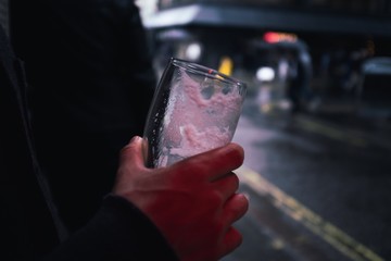 Empty pint of beer in hand on street in a pub in Soho, London