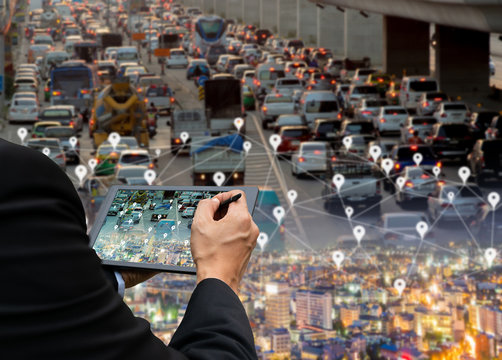 Businessman holds a tablet car on the road network technology of digital map in the city