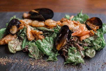 Seafood salad. Warm salad with leaves, shrimp, mussels and sause.