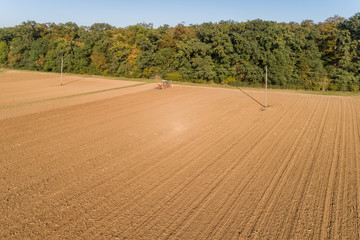 Fototapeta na wymiar Traktor säht Wintergetreide im Herbst