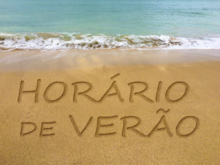 Summer time written in the sand on a beautiful Brazilian beach (translation portuguese: summer time).
