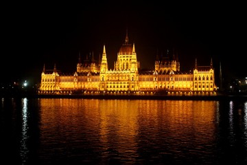 Fototapeta na wymiar Parlamento de Budapest iluminado en la noche y reflejo en el río Danubio