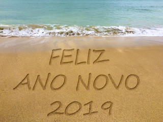 Happy new year 2019 written in the sand on a beautiful Brazilian beach (translation...