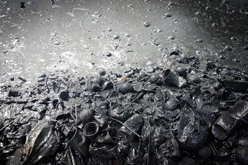 Plastic and other rubbish discarded in polluted muddy water
