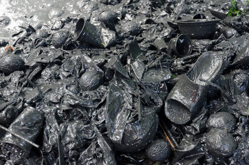 Plastic and other rubbish including discarded slipper in polluted muddy water