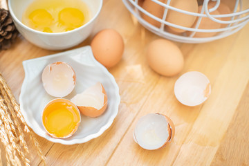 Fresh farm eggs on a wooden background. separated egg white and yolk. Eggs in bowl for cooking omelet.