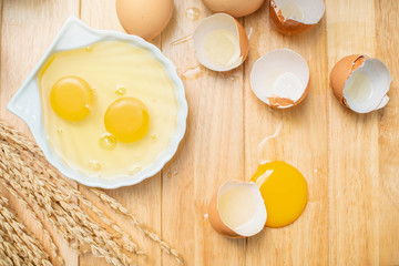 Fresh farm eggs on a wooden background. separated egg white and yolk. Eggs in bowl for cooking omelet.
