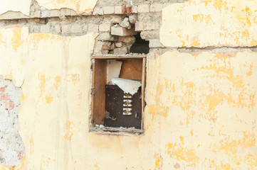 Broken and damaged electric fuse box on demolished house in the war conflict zone