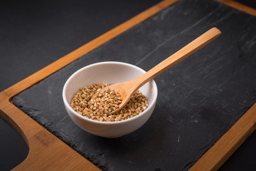 Man hand holding spoon with organic buckwheat