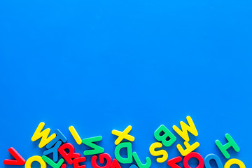 Alphabet for kids concept. English letters in disorder on blue background top view copy space