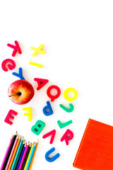 Primary school concept. Letters of english alphabet, book, apple and color pencils on white background top view copy space