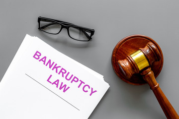 Words bankruptcy law written on the documents near judge gavel on grey background top view