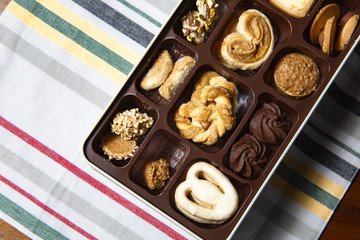 Variety of cookies are placed in the plastic tray, and put on the cloth ( napkin ) with a beautiful pattern.