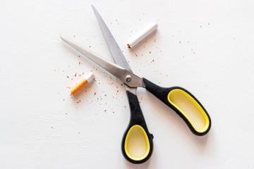 stop smoking cigarettes concept. scissors and a cut cigarette on a white background