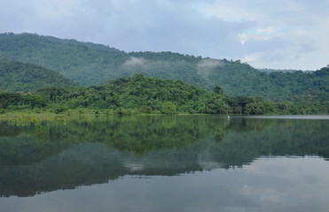 Fototapeta na wymiar fishery boat floating on lake with mountain background
