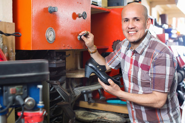 Professional shoemaker heeling footwear on machine