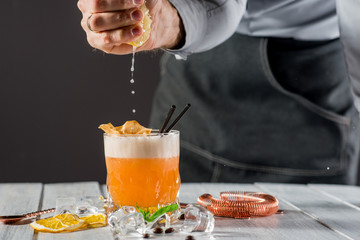 A barman preparing cocktail with lemon juice