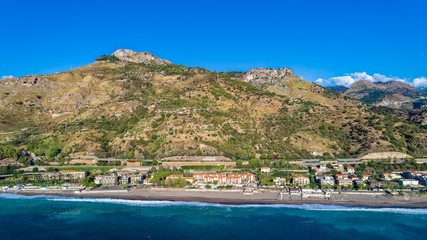 Aerial. Beach view near Taormina.  Taormina has been a tourist destination since the 19th century. Located on east coast of the island of Sicily, Italy.