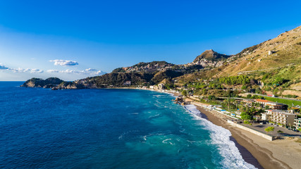 Aerial. View from beach toTaormina.  Taormina has been a tourist destination since the 19th century. Located on east coast of the island of Sicily, Italy.