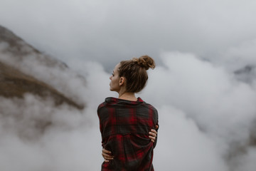 Woman above the clouds in the mountains