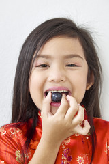 Little girl Eating Black grape
