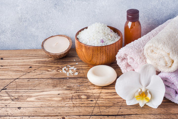 Spa and Wellness concept on wooden background. Terry towel and cosmetic oil for massage.