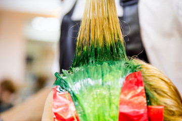 Professional hairdresser dyeing hair. Multicolor with stretching coloring. Fluorescent staining