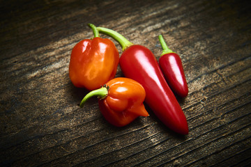 Group of Red fresh chilli on old rustic wood desk. Food background. Cooking. Selective focus