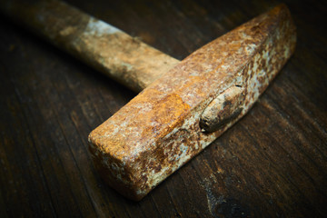 Close up of old used hammer on a rustic wooden background. Selective focus
