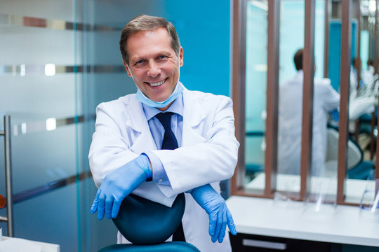 Your dream doctor. Cheerful dentist looking at camera with smile while sitting in dentist’s office