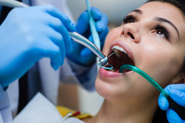 Taking a closer look. Close-up of dentist examining his beautiful patient in dentist’s office