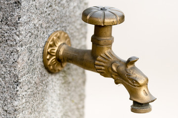 old brass faucet with golden decorations