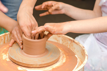A close-up of the child learns to knead the clay