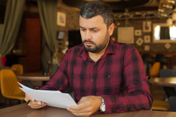 Worried man looking at papers