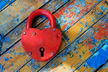 Red padlock in the form of heart on a wooden shabby background