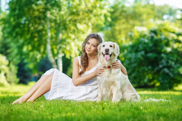 Young woman with golden retriever dog in the summer park
