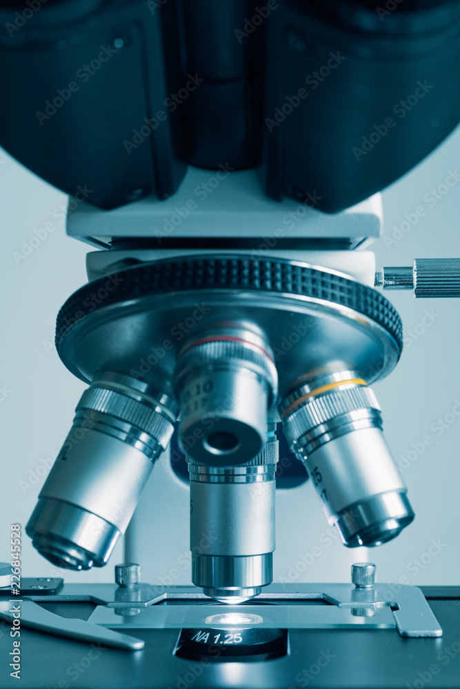 Wall mural close-up shot of modern microscope with sample slide at laboratory.