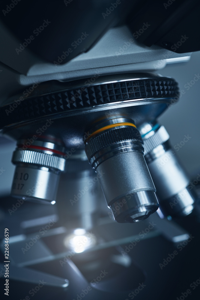 Wall mural close-up shot of modern microscope with sample slide at laboratory.