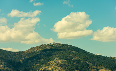 a lonely sunny mountain in autumn with clouds in spain