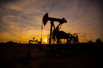 In the evening, the outline of the oil pump. The oil pump, industrial equipment. Oil field site,...