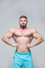 Strong Athletic Man Fitness Model Torso showing six pack abs. isolated on grey background with copyspace