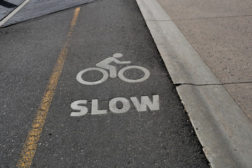 Slow word with bike symbol painted on the road