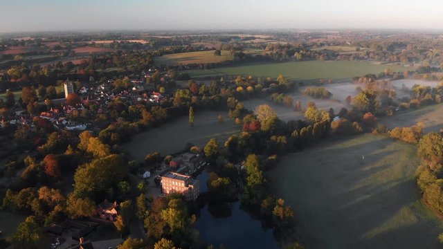 Aerial footage of Dedham featuring the village and church in the early morning with mist lying in the fields.