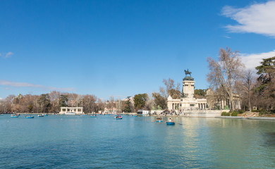 Fototapeta premium Osoby korzystające z rejsu łodzią po stawie w parku El Retiro w Madrycie w Hiszpanii.
